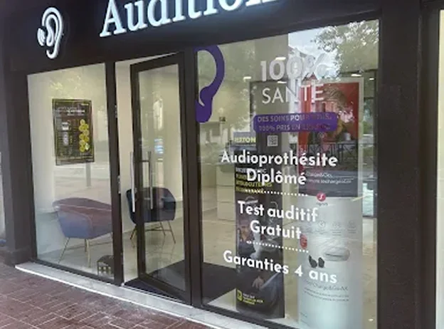 Façade de magasin Audition, avec des affiches sur les services et un logo d'oreille à Montigny-le-Bretonneux dans les Yvelines 78