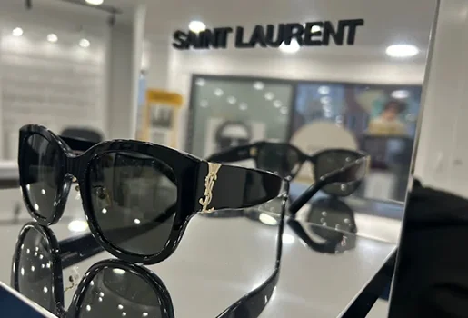 Lunettes de soleil noires Saint Laurent avec logo doré sur un présentoir en magasin à Montigny-le-Bretonneux dans les Yvelines 78