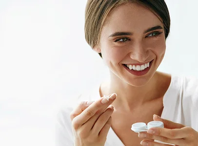 Jeune femme souriante tenant une lentille de contact et son étui à Montigny-le-Bretonneux dans les Yvelines 78