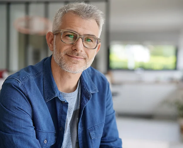 Homme souriant d'âge moyen avec des cheveux gris et des lunettes, chemise en jean à Montigny-le-Bretonneux dans les Yvelines 78